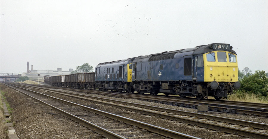 A pair of Class 25 Bo-Bo diesel locomotives, nos.25104 & 25037, bring a train down the chord from the ex-Great Central Railway to the Midland Main Line south of Loughborough, 9/7/75.