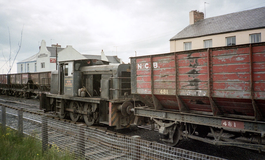 NCB 0-6-0 diesel locomotive no. 20-110-704 with a train of empty wagons in the centre of Seaham